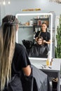 hairstylist spraying hair of happy woman Royalty Free Stock Photo