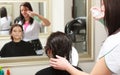 Hairstylist spraying hair woman client in hairdressing beauty salon Royalty Free Stock Photo