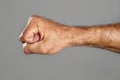 Hairy man fist closeup expression over gray