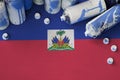 Haiti flag and few used aerosol spray cans for graffiti painting. Street art culture concept