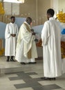 Haitian priest incenses the altar during mass.