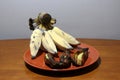 Hak Muk banana, Thai language name. Grilled and ripe banana in the brown dish on the wooden table.