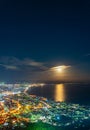 Hakodate City night view from Mt. Hakodate observatory, big bright moon light up the sea, golden reflection on surface