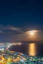 Hakodate City night view from Mt. Hakodate observatory, big bright moon light up the sea, golden reflection on surface Royalty Free Stock Photo