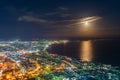 Hakodate City night view from Mt. Hakodate observatory, big bright moon light up the sea, golden reflection on surface Royalty Free Stock Photo