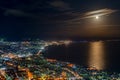 Hakodate City night view from Mt. Hakodate observatory, big bright moon light up the sea, golden reflection on surface Royalty Free Stock Photo