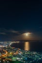 Hakodate City night view from Mt. Hakodate observatory, big bright moon light up the sea, golden reflection on surface Royalty Free Stock Photo