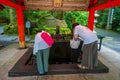 HAKONE, JAPAN - JULY 02, 2017: Unidentified people drinking water at the enter of red Tori Gate at Fushimi Inari Shrine Royalty Free Stock Photo