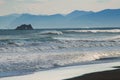 Halaktyr beach. Kamchatka. Russian federation. Dark almost black color sand beach of Pacific ocean. Stone mountains and Royalty Free Stock Photo