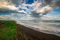 Halaktyr beach. Kamchatka. Russian federation. Dark almost black color sand beach of Pacific ocean. Stone mountains and yellow gra Royalty Free Stock Photo