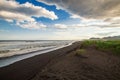 Halaktyr beach. Kamchatka. Russian federation. Dark almost black color sand beach of Pacific ocean. Stone mountains and yellow gra Royalty Free Stock Photo