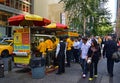 The Halal Guys food cart with large umbrella and a long queue line during lunch hours serving the people of New York
