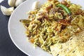 Halal Indian chicken Biryani served with yogurt tomato raita over white background. Selective focus