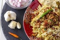 Halal Indian chicken or mutton Biryani served with yogurt tomato raita over white background. Selective focus