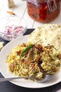 Halal Indian chicken or mutton Biryani served with yogurt tomato raita over white background. Selective focus