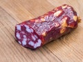 Half of an appetizing sausage on a wooden background, close-up shot. Food on a cutting board Royalty Free Stock Photo