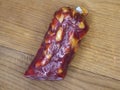 Half of an appetizing sausage on a wooden background, close-up shot. Food on a cutting board. Smoked sausage on a wooden rustic Royalty Free Stock Photo