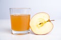 Half apple with glass of naturally cloudy juice