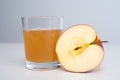 Half apple with glass of naturally cloudy juice