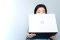 Half of Asian business woman FACE, holding laptop over BLUE sky background with copy text space, Looking at camera. Royalty Free Stock Photo