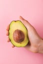 Half of avocado with kernel in female hand Royalty Free Stock Photo