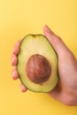 Half of avocado with kernel in female hand Royalty Free Stock Photo