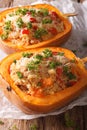 Half baked pumpkin with couscous, meat, vegetables and cheese