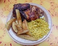 Half barbecue chicken with yellow rice and potato wedges