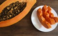 Half a beautiful papaya and three slices on a plate