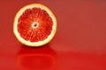 Half of a blood orange on a red background