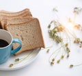 The half of blue ceramic coffee cup ,on white desk,with sliced bread in white dish Royalty Free Stock Photo