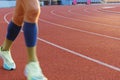 Half-blurred legs of a runner in motion on a running track around the stadium Royalty Free Stock Photo