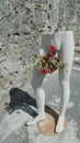 Half body of a mannequin with a pot of flower next to the stone wall on the sidewalk in Karlobag, Croatia