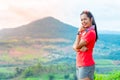 Half-body photo of a female trail runner wearing pink runner, sportswear, smiling, looking at the camera. on the gravel ground on