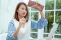 Half-body portrait of an Asian woman in a white shirt sitting in a bakery examining her purse for money with a stressed, unhappy Royalty Free Stock Photo