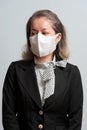 Half body portrait of middle-aged mixed race woman in formal wear wearing white disposable 3D face mask for protection against nov Royalty Free Stock Photo