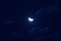 Half of bright moon among dark clouds in night sky with