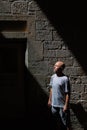 Half-Bust Portrait of a Man in a Diagonal Light Beam Crossing a Stone Wall with Windows, Contrast, Light Dark