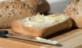 Half a Buttered Ciabatta Bread Roll with Knife. Royalty Free Stock Photo