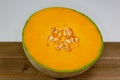 Half a cantaloup sitting on the kitchen table waiting to be eaten