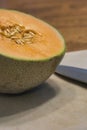 cantaloupe and knife on white cutting board on table Royalty Free Stock Photo