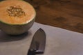 half cantaloupe with seeds on cutting board with a knife Royalty Free Stock Photo