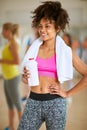 Half-caste woman with towel and bottle of protein shake after tr