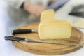 Half cheese head on on wooden market board. Gastronomic dairy produce, real scene in the food market Royalty Free Stock Photo