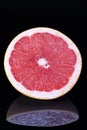 Half of citrus fruit of red grapefruit isolated on black background close up Royalty Free Stock Photo