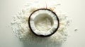 Half a coconut with shredded coconut flakes spilling on a white table top view Royalty Free Stock Photo