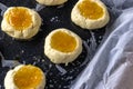 Half cooked jam filled thumb print cookies on a baking tray with copy space