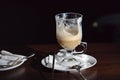 Half cup of cafe latte coffee left in the white coffee cup on the white saucer and white coffee spoon on the side Royalty Free Stock Photo