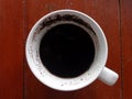 half of a cup coffee was left with dregs one rainy afternoon shot closely in wood background Royalty Free Stock Photo