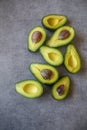 Half cut ripe avocados with seed on dark grey background, top view flt lay